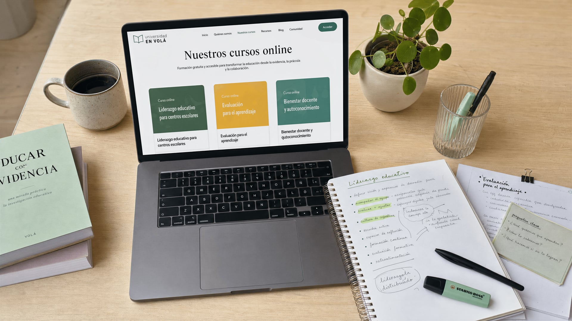 En Volá online course curriculum displayed on a laptop beside annotated education notes